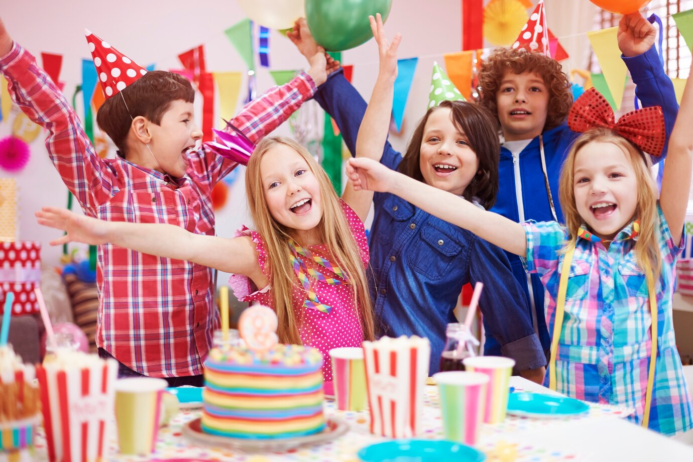 Niños celebrando en un cumpleaños rodeados de otros niños.